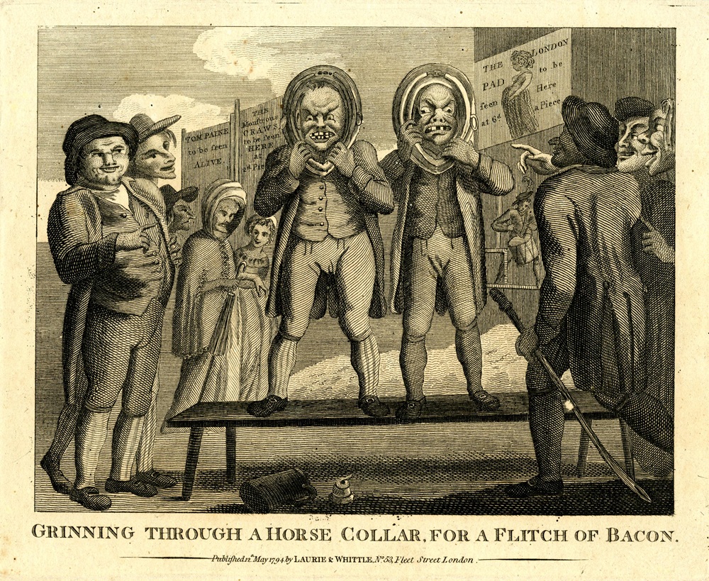 "Grinning through a horse collar, for a flitch of bacon" a satirical print showing a scene at a country fair. Two men standing side by side on a form grimace horribly through horse-collars.
