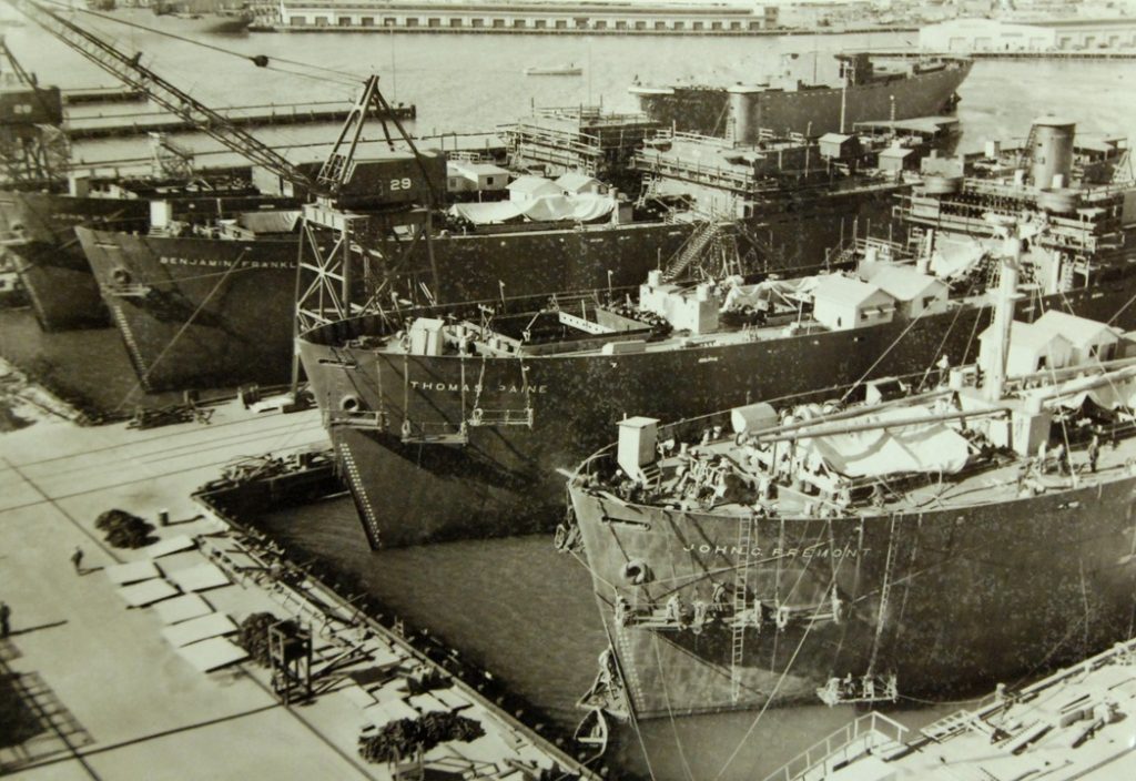 The SS Thomas Paine was a 10,000-ton freighter, part of an armada that was mass produced for the American 'Liberty Ship' intiative to deliver arms and vital food supplies to the war front during World War II. This scene is Los Angeles, California, and the vessels include, (left to right), SS John C. Fremont, SS Thomas Paine and the SS Benjamin Franklin - National Museum of the U.S. Navy